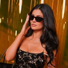 a woman with dark hair wearing dark sunglasses