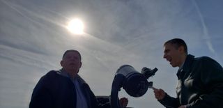 Amateur astronomer Artie Kunhardt (left) and a high school assistant principal stand near a telescope in Floyd Bennett Field, New York. They are gathered with about a dozen other guests to observe Mercury transit the sun on Monday (Nov. 11).