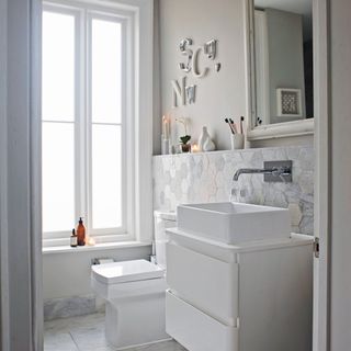 white bathroom with subtle tile design and white sink