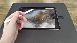 Darkboard iPad drawing stand; a person rests their hand on the side of a black drawing stand