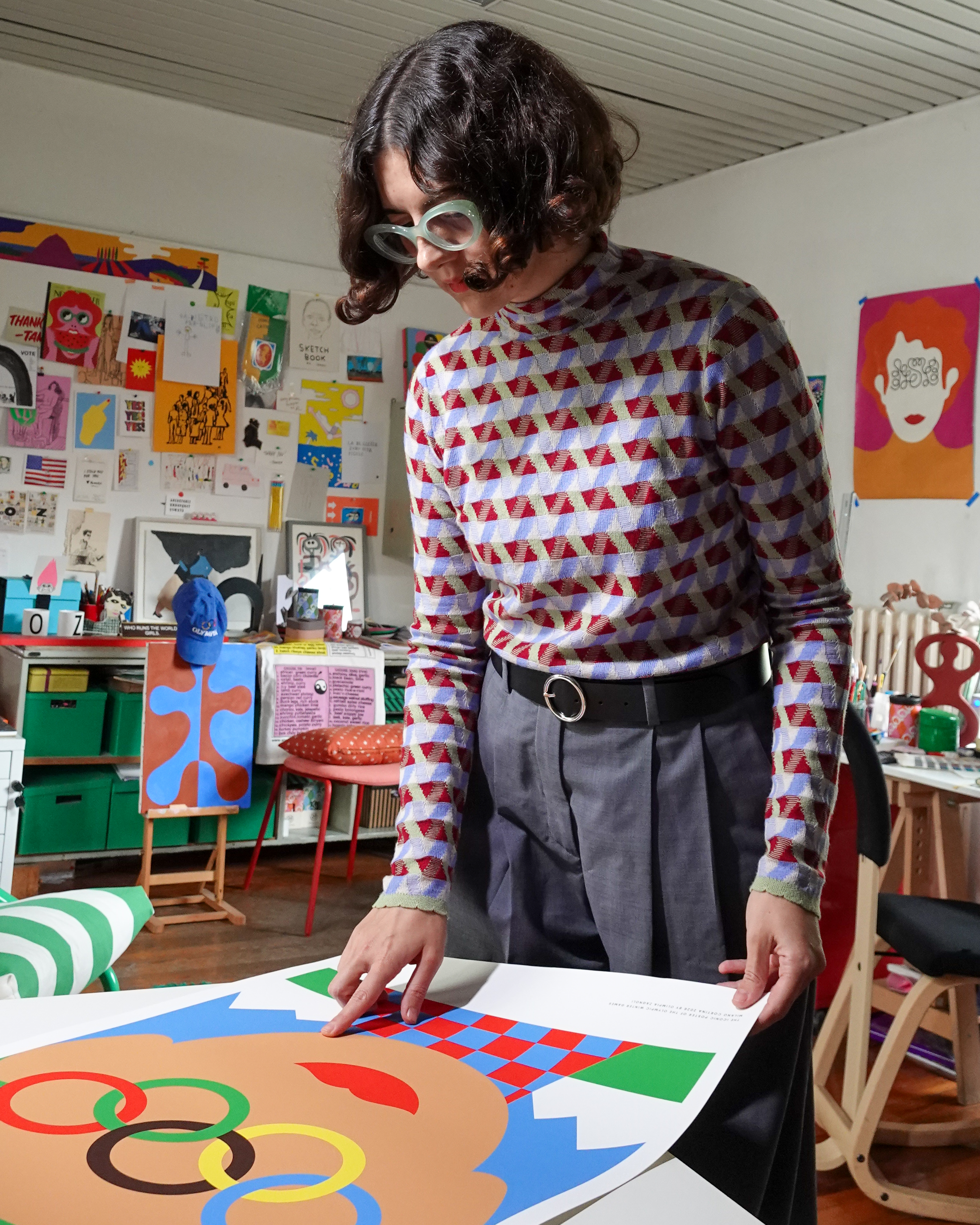 woman looking at Olympics poster in a busy studio