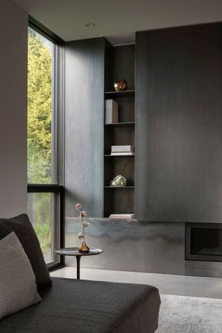 Living area with concrete floor, grey walls and patina metal finish