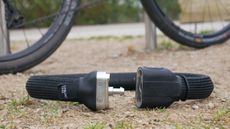 litelok core plus resting on the ground next to a bike at a bike rack unlocked. A high security wearable bike lock