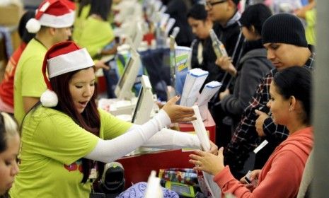 A customer carries shopping bags on Black Friday: The first day of the holiday shopping season saw record numbers of shoppers and sales.