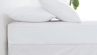 White fitted sheet on bed with white duvet and white pillow