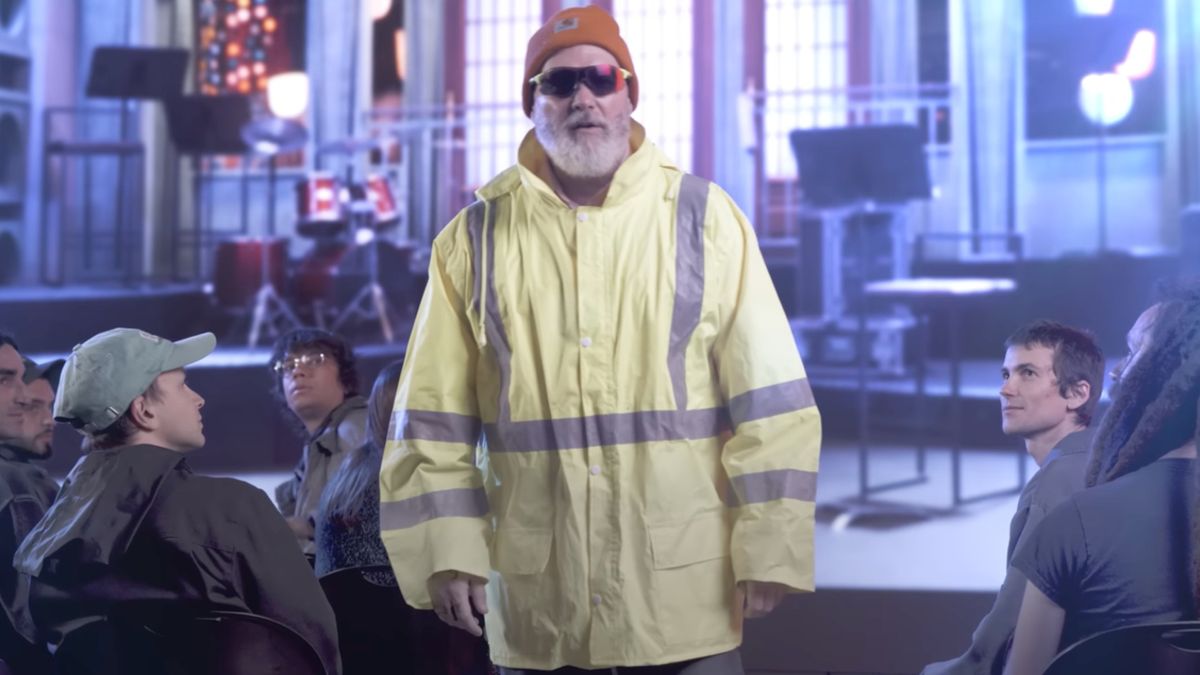 Fred Durst in an orange hat, sunglasses and a hi-vis jacket