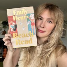 emily henry holds up a special copy of her novel beach read