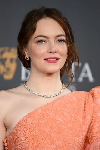 Emma Stone is seen with a side-swept wavy bun at theattends the 2024 EE BAFTA Film Awards at The Royal Festival Hall on February 18, 2024 in London, England.