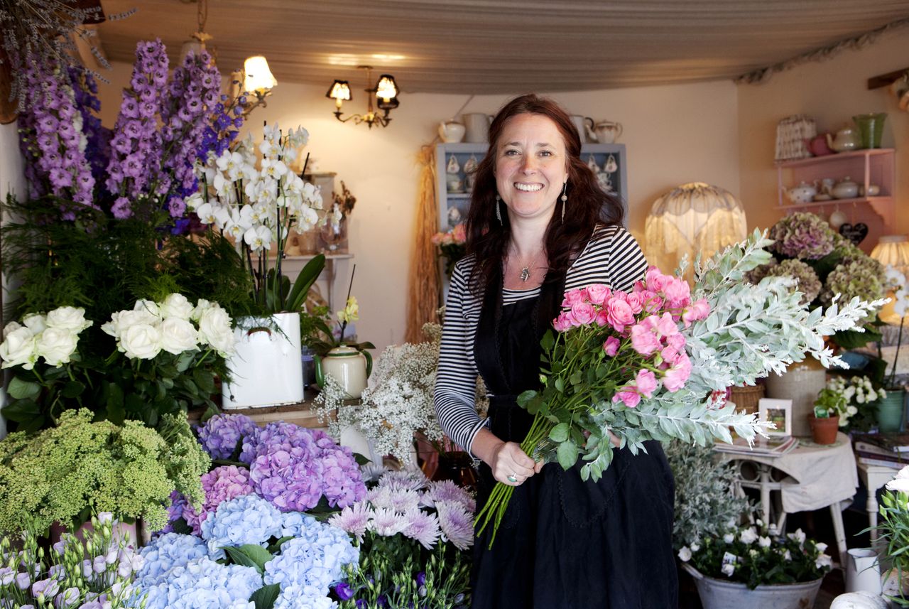 florist with flowers in shopfront