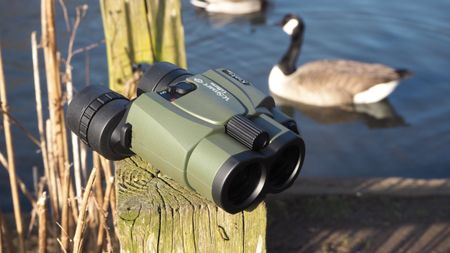 Kenko VC Smart Cellarto 10x30 WP binoculars on a wooden bench outside in front of a lake