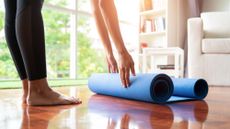 Person rolls up a yoga mat on the floor