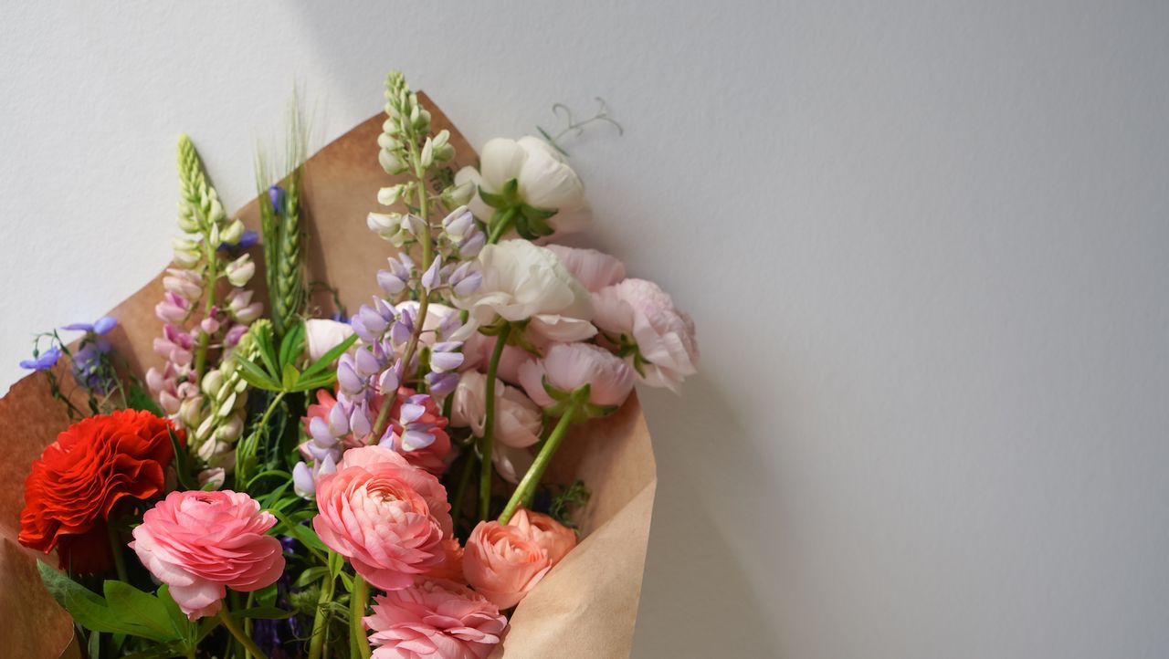 Bouquet of mixed flowers wrapped in paper on a white background