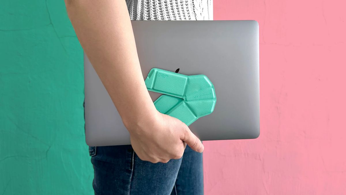 The foldable OriMouse in "elegant blue", being held flat against a laptop