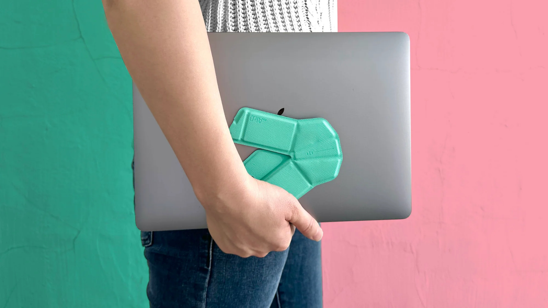 The foldable OriMouse in "elegant blue", being held flat against a laptop