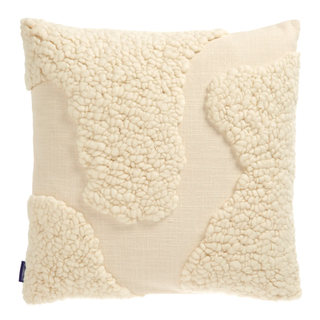 cream tufted pillow with a curved pattern