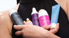 A close up of a person holding a selection of Paula's Choice products. 