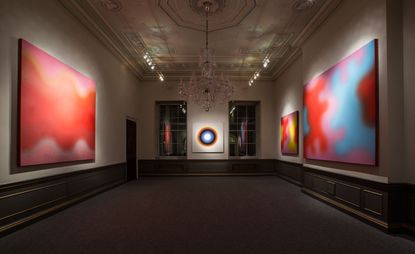 An art gallery with large colourful abstract paintings on the walls.
