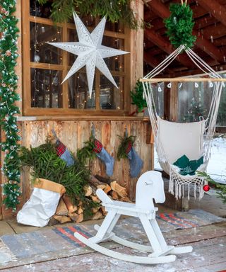 front porch with festive decor and hanging chair