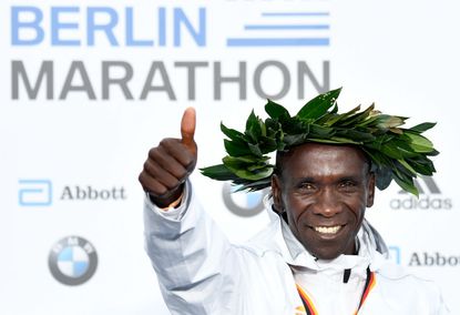Kenya's Eliud Kipchoge celebrates on the podium during the winner's ceremony after winning the Berlin Marathon setting a new world record on September 16, 2018 in Berlin.