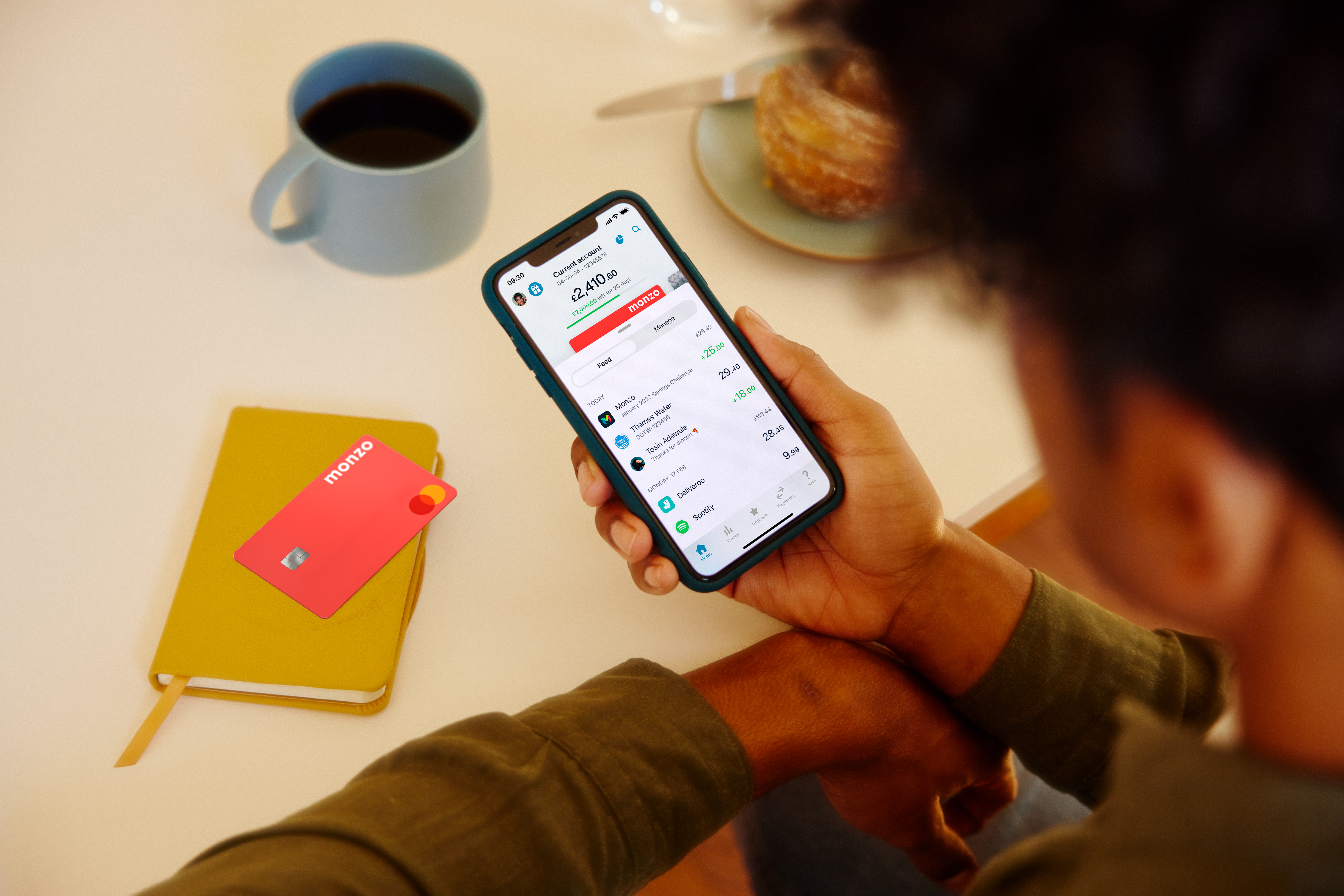 Image of a Monzo app seen over the shoulder of the man using it