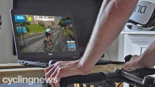A cyclist on a smart trainer, with a Dell computer in front of him, with Zwift on the screen