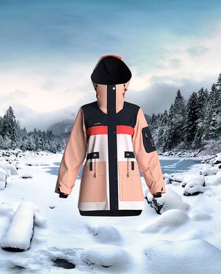 A red, black, pink and white high necked jacket with a snow covered river behind it.