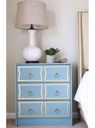 A chest of drawers painted blue with white overlay trim on the drawers