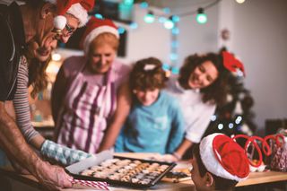family gathered around Christmas cookie baking