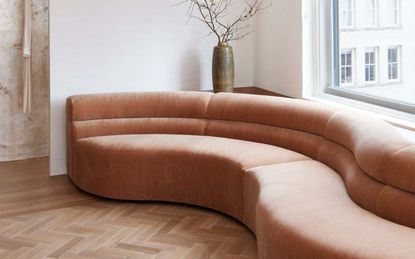 A curved sofa in pale pink