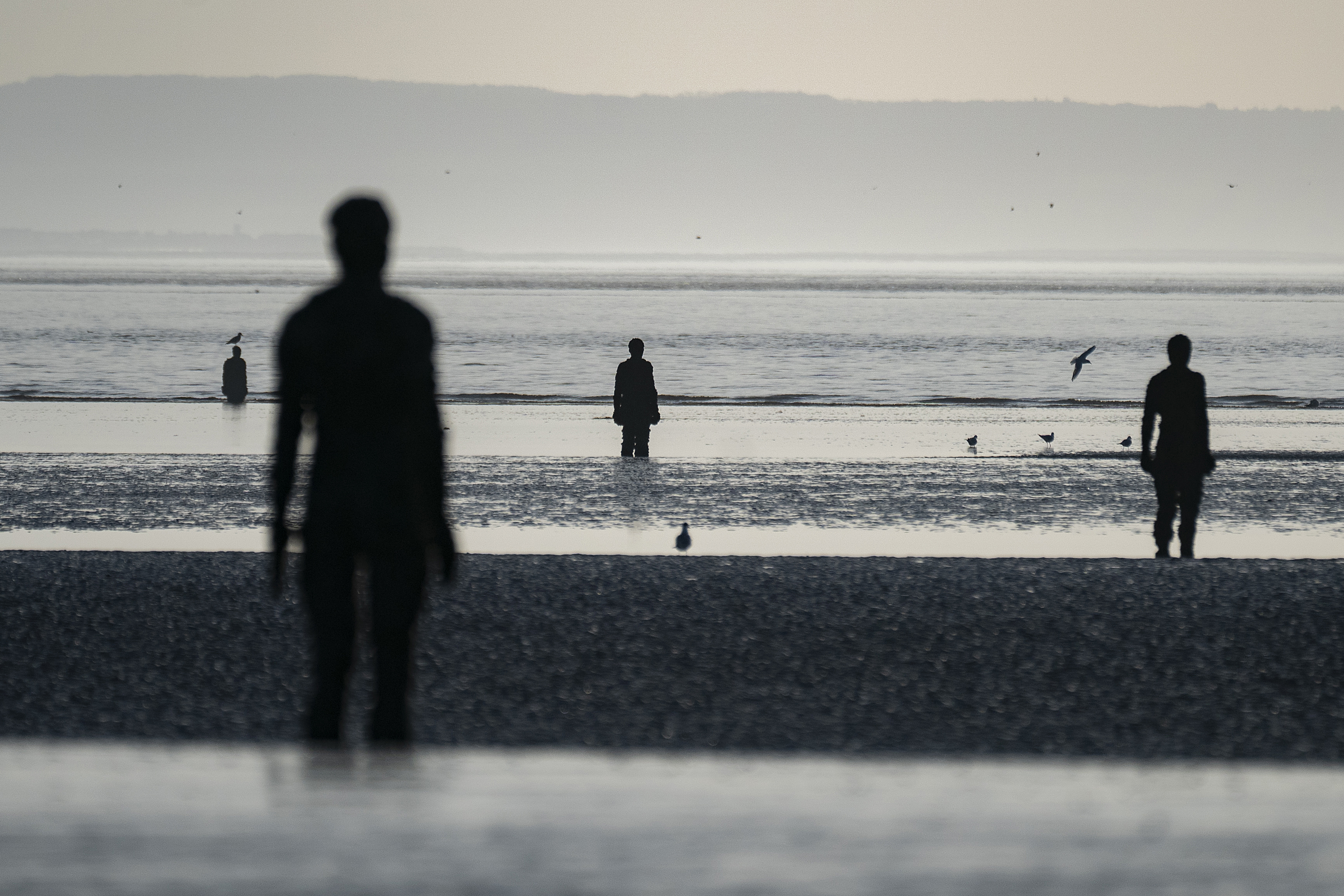 Antony Gormley's Another Place sculptures on a beach in Liverpool