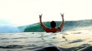 Surfer throwing horns