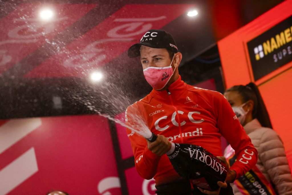 Team CCC rider Czech Republics Josef Cerny celebrates with a bottle of champagne on the podium after winning the 19th stage of the Giro dItalia 2020 cycling race a 258kilometer route between Morbegno and Asti on October 23 2020 Heavy rain has interrupted on October 23 2020 the 19th stage of the Giro dItalia following protests by the riders in the face of difficult weather conditions Todays stage was planned to be a flat 258km ride between Morbegno and Asti but was cut back 100km after riders revolted when faced with pelting rain in the northern region of Lombardy Photo by Luca Bettini AFP Photo by LUCA BETTINIAFP via Getty Images
