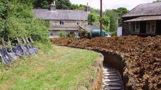 horizontal ground source heat pump array being laid in large garden