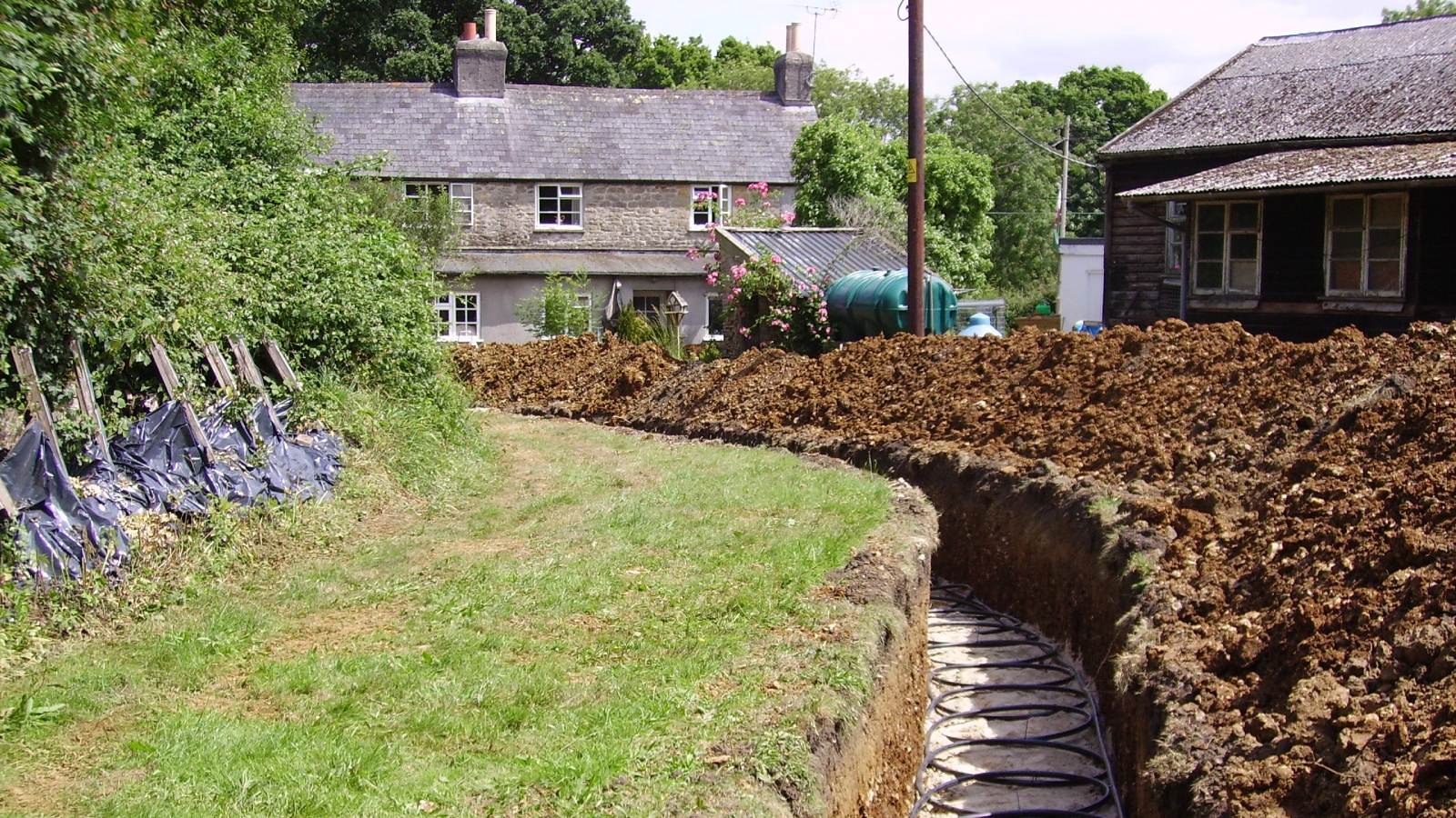 horizontal ground source heat pump array being laid in large garden
