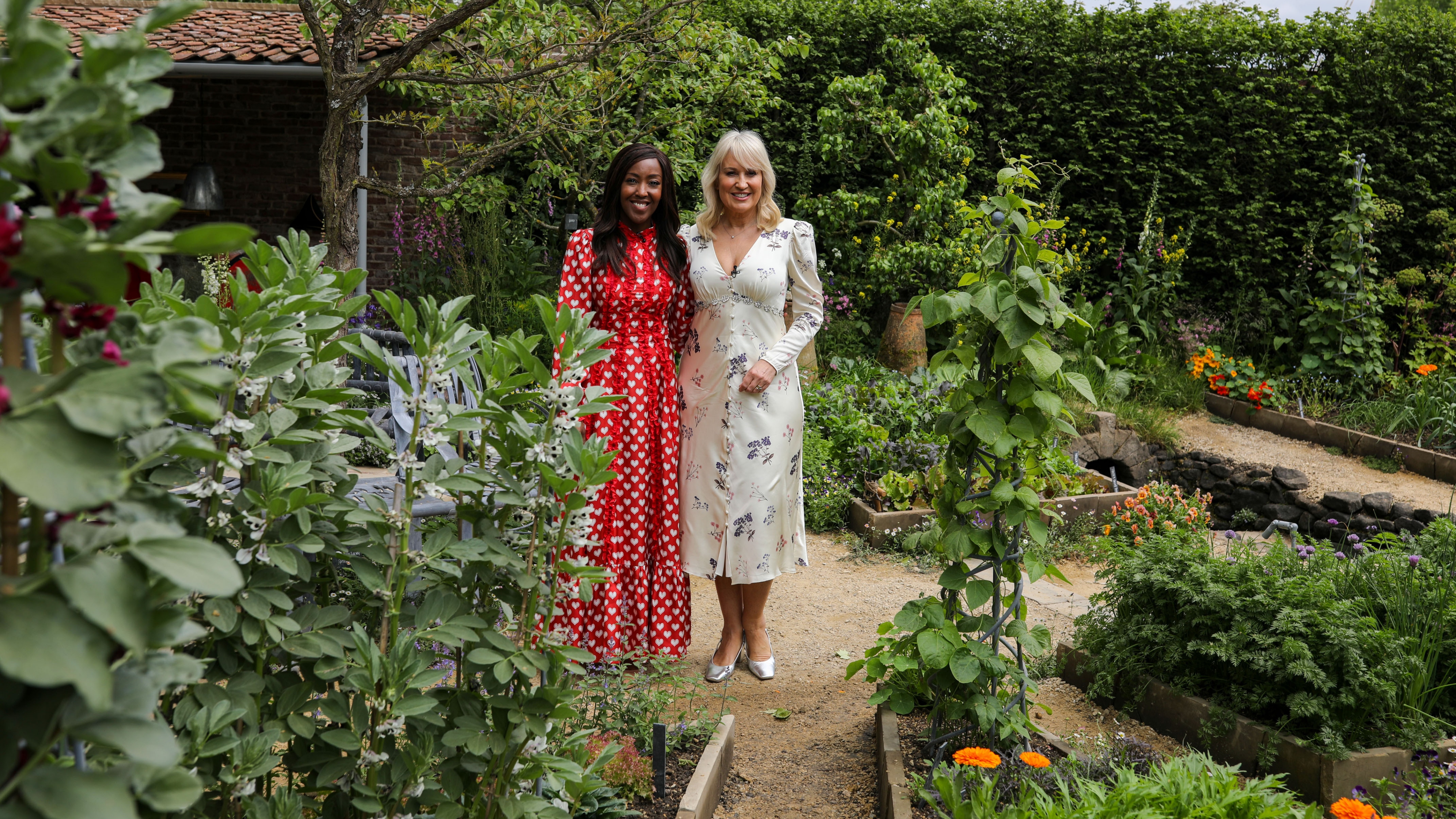 Angellica Bell and Nicki Chapman standing in a garden for The RHS Chelsea Flower Show 2025