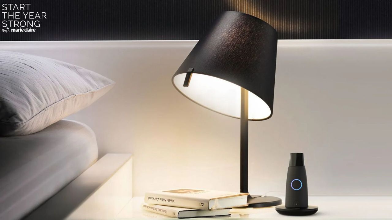 Image showing the Lumen metabolism device on a bedside table next to a lamp