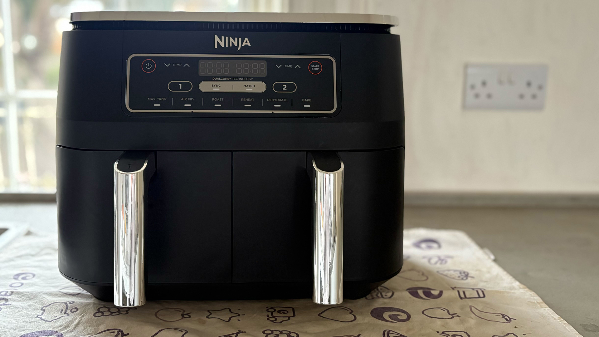 Double drawer Ninja air fryer on a tea towel placed on a kitchen countertop