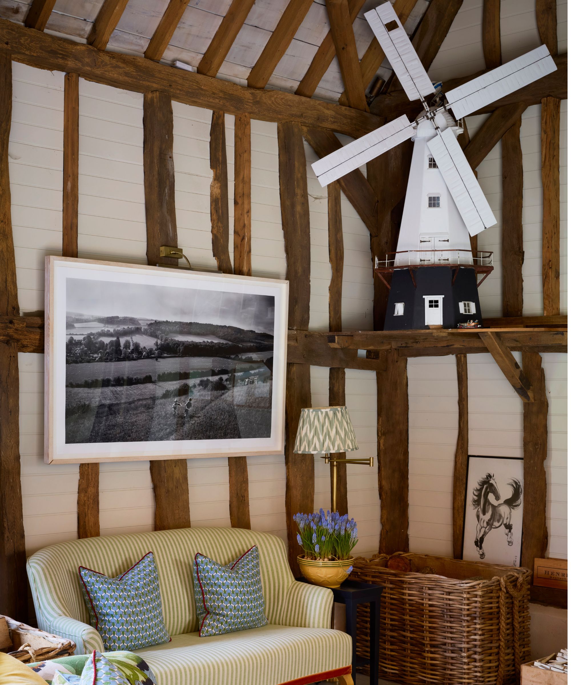 a rustic beamed barn with a shelf displaying a vintage windmill