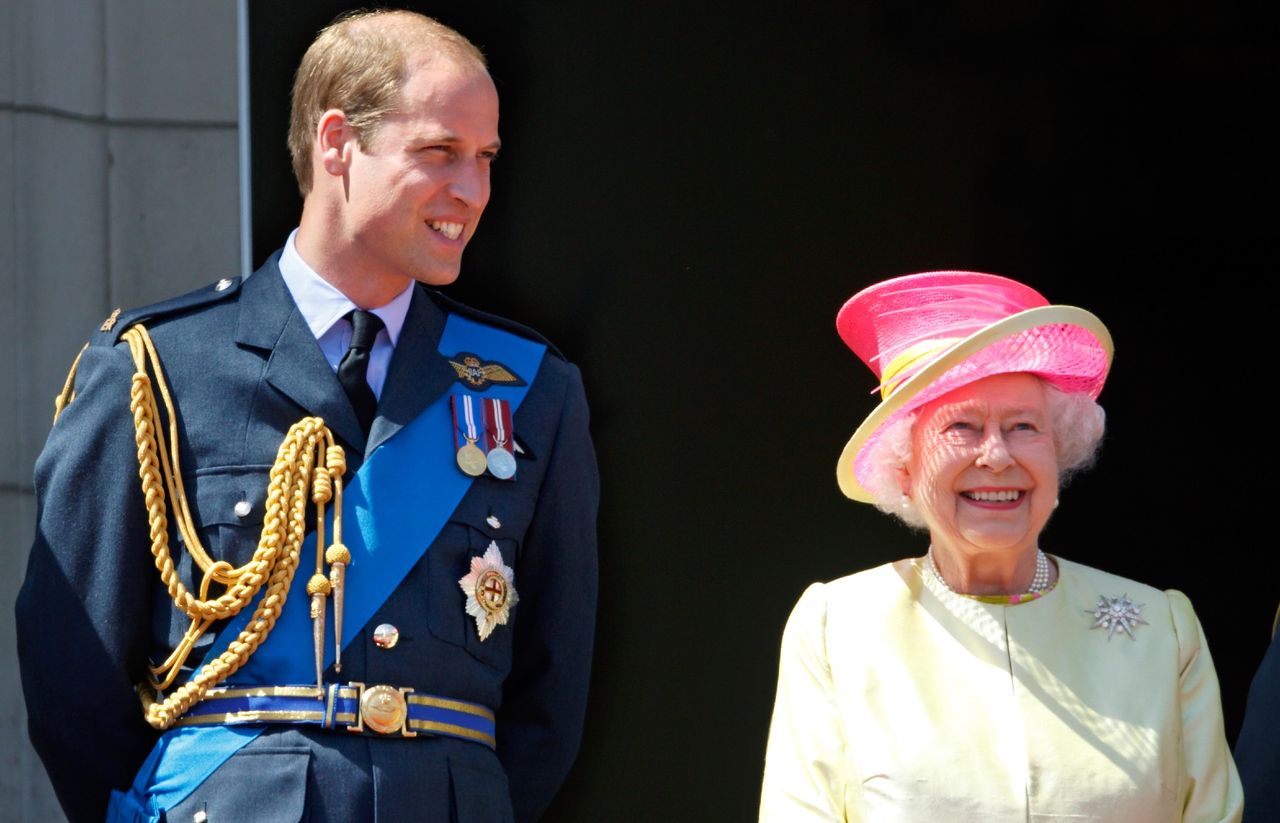 Prince William, Duke of Cambridge and Queen Elizabeth II watch a flypast of Spitfire &amp; Hurricane aircraft from the balcony of Buckingham Palace