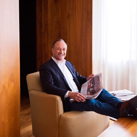 Doug Emhoff seated in his office reading a newspaper