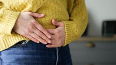 a woman clutches her belly in pain