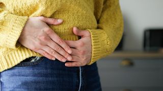 a woman clutches her belly in pain