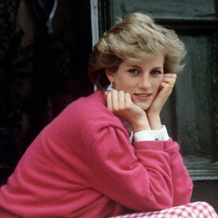 Princess Diana wearing a pink shirt putting her elbows on her knees
