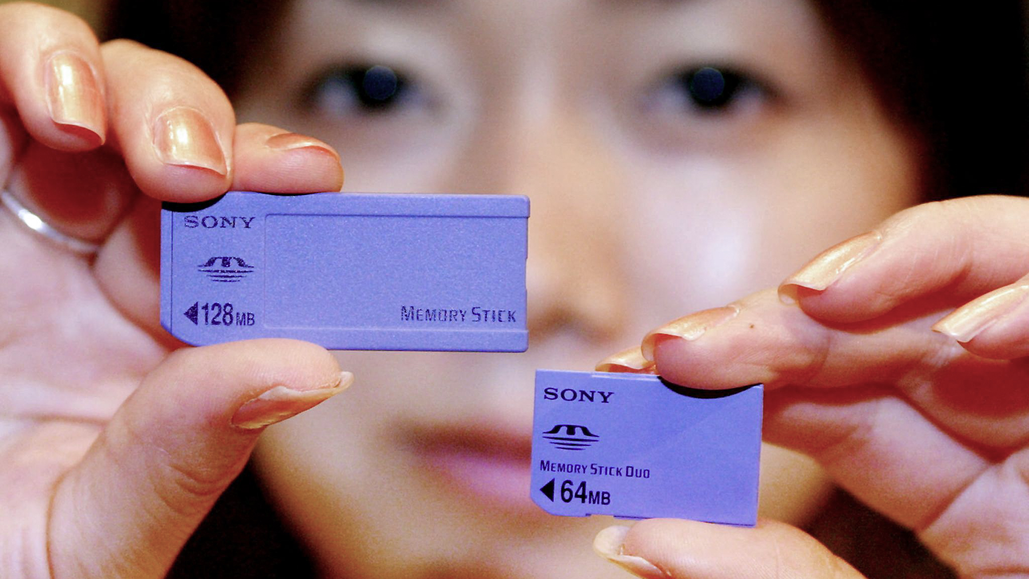 Japan's electronics giant Sony employee Risa Kakizawa displays the new tiny sized IC memory card &amp;quot;Memory Stick Duo&amp;quot; (R) and the regular sized &amp;quot;Memory Stick&amp;quot; during the Memory Stick Forum at a Tokyo hotel 03 June 2002. Sony will launch the new &amp;quot;Memory Stick Duo&amp;quot;, measuring 31 x 20 x 1.6mm and weighing only 2g, for the small electronics appliance at the domestic market from the next month. Photo by YOSHIKAZU TSUNO / AFP