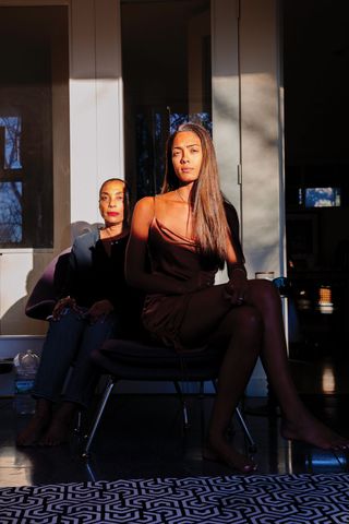 Photography by Olivia Joan of 2 women sat in a chair infront of a glass door