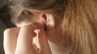 Close-Up Of Woman Wearing Earring - How to treat an ear piercing infection