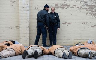 guards talk while prisoners lie on the ground in orange is the new black