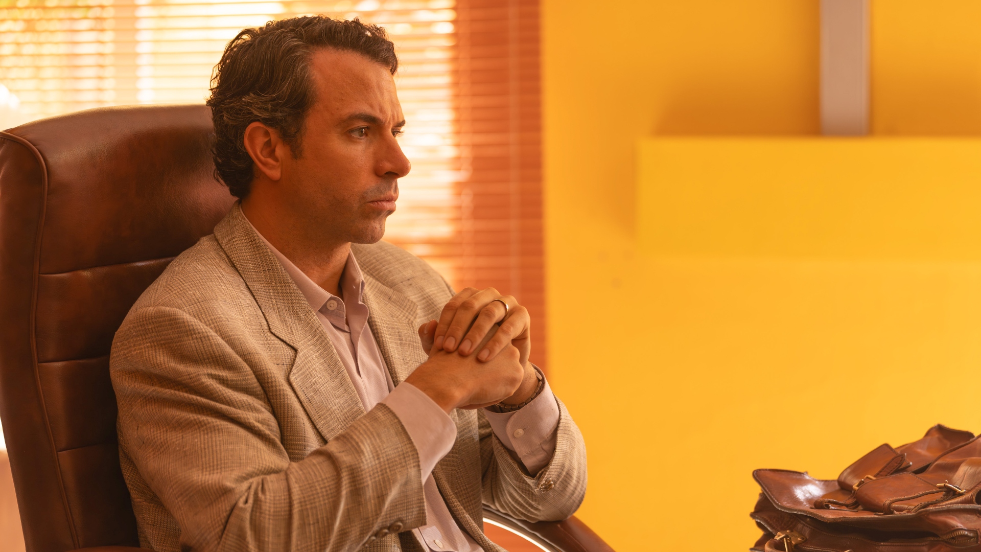 John sits at his desk in The Gold season 2