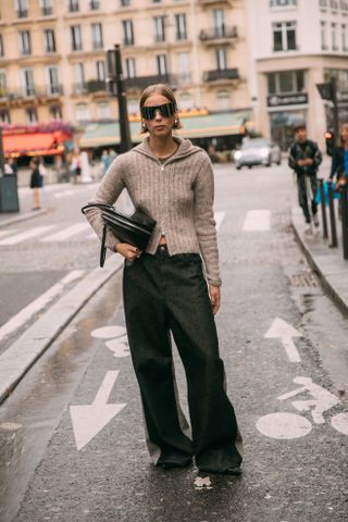 woman wearing zip-up sweater and baggy pants