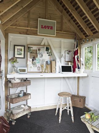 hobby room in outbuilding summer house with desk and stool